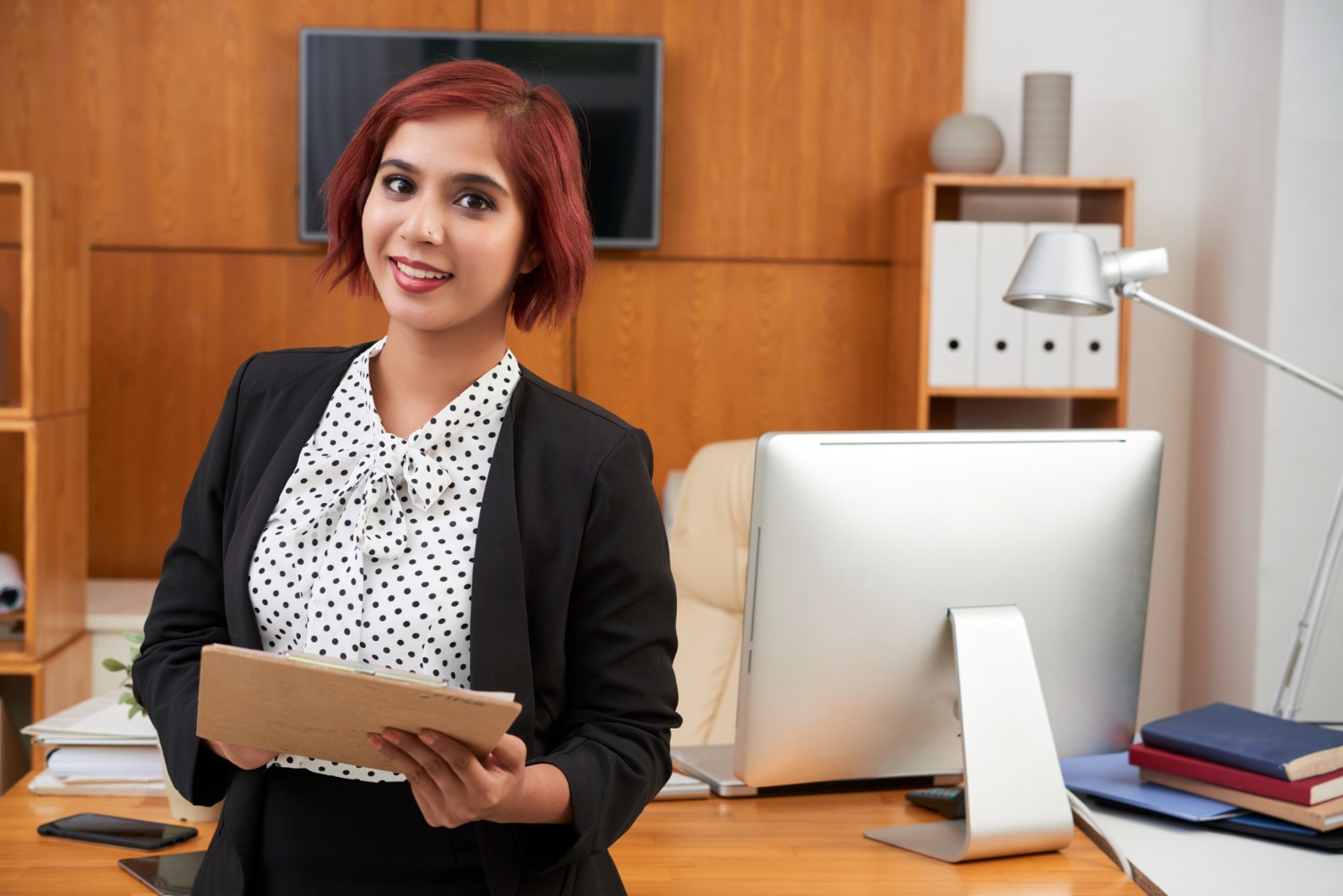 Businesswoman with folder indicating What AML Training Programs Should Cover in 2025