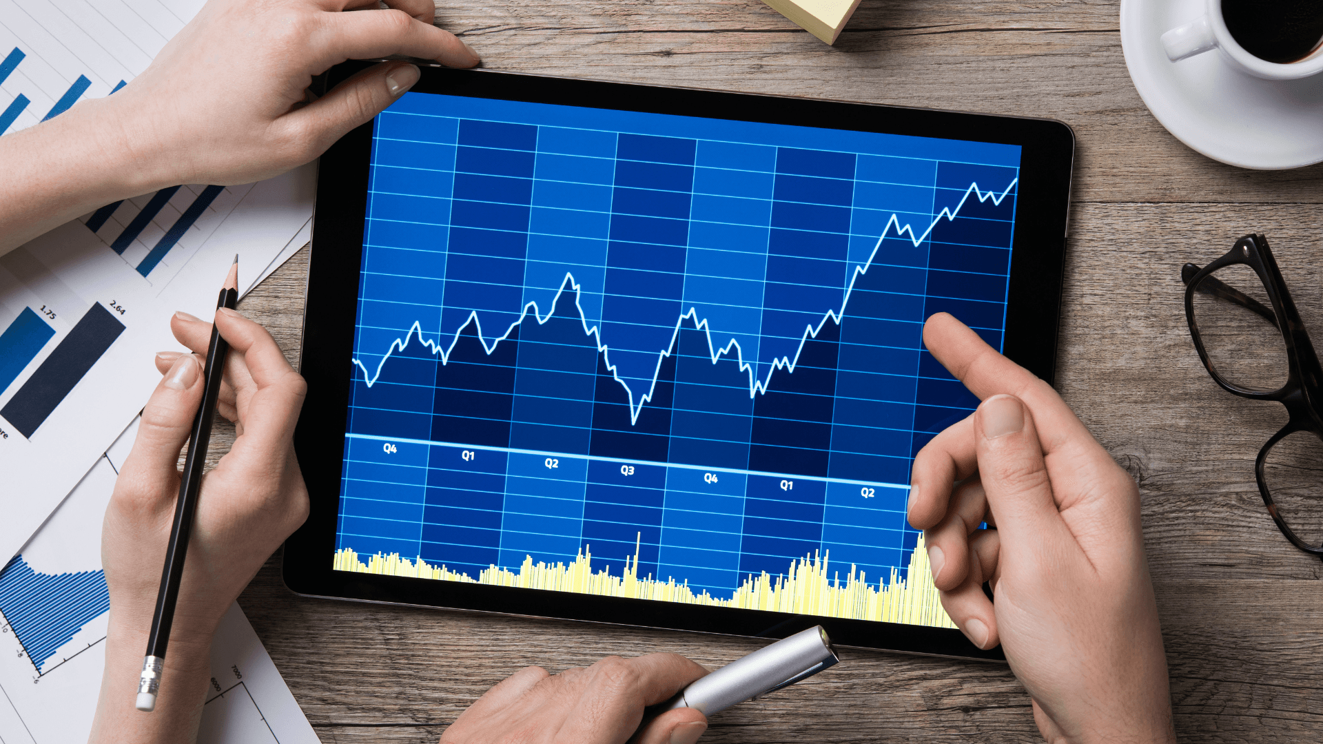 this image shows a tab with a stock market graph and a person touching the tab